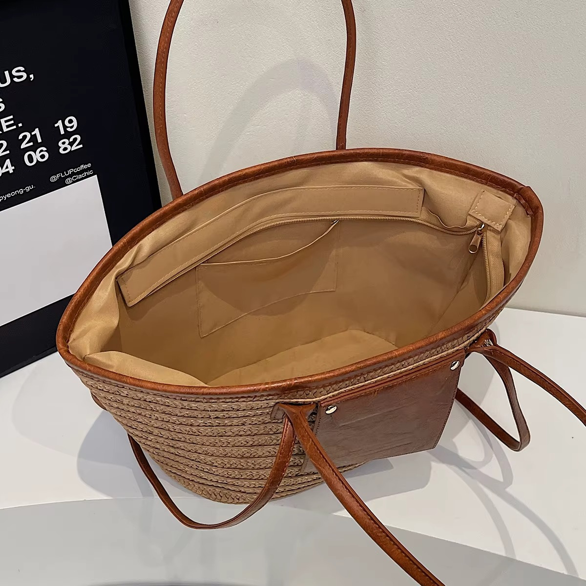 Intérieur du sac en paille tressée cabas Constance avec poche en cuir et doublure beige