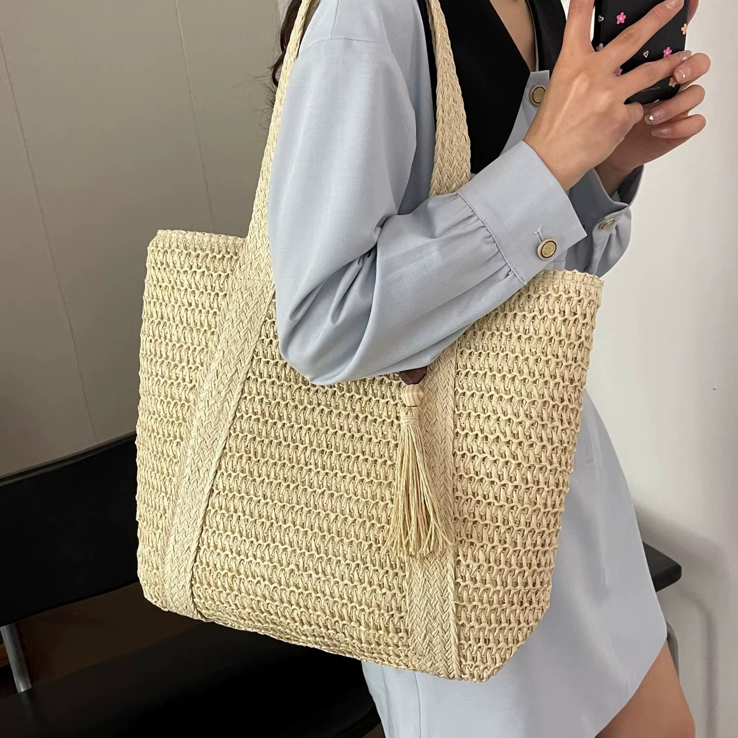 Sac En Paille Tressée Bandoulière – Paolita Sac en paille tressée beige avec bandoulière large et pompon suspendu porté sur l'épaule