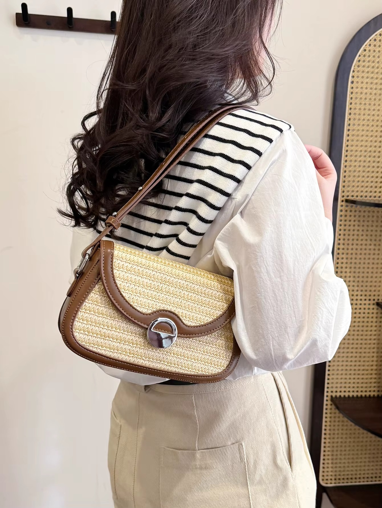Sac en paille bandoulière avec rabat arrondi et bordure cuir marron porté sur l'épaule