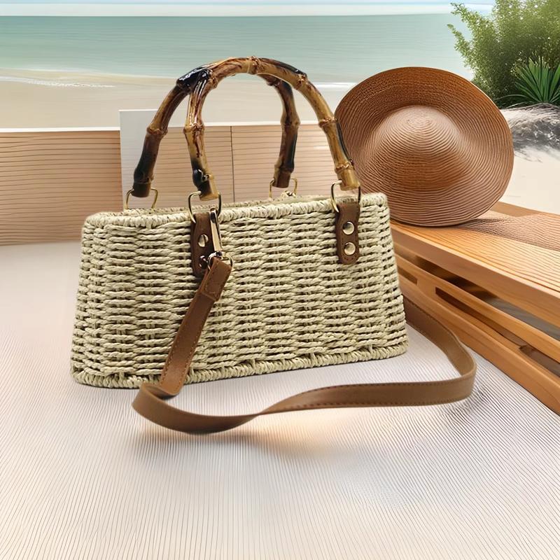 Sac en paille cabas Rosemonde avec poignée en bambou et bandoulière en cuir marron posé sur une surface claire avec un chapeau de paille en arrière-plan
