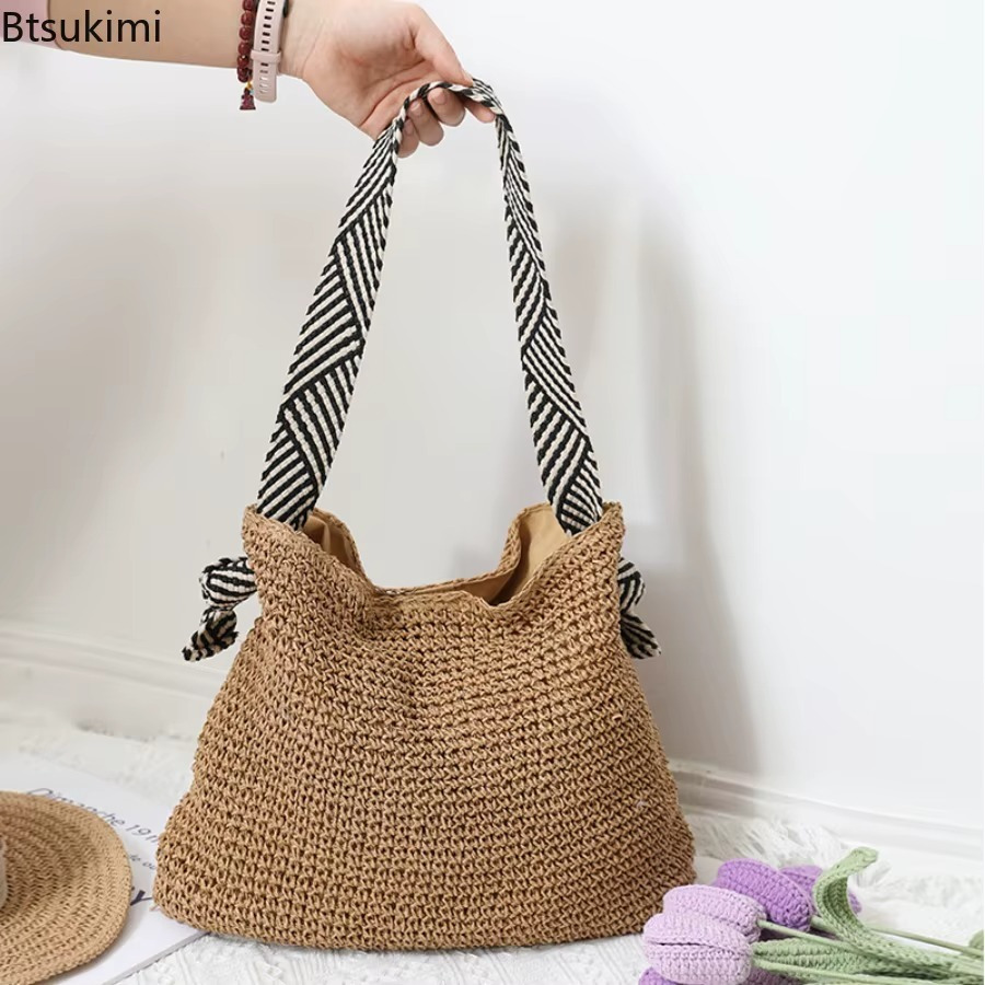 Sac en paille crochet bandoulière rayée noir et blanc modèle Bertille tenu à la main