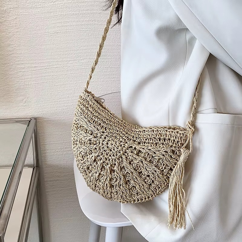 Sac en paille demi-cercle avec pompon et bandoulière tressée modèle Amandine porté sur épaule