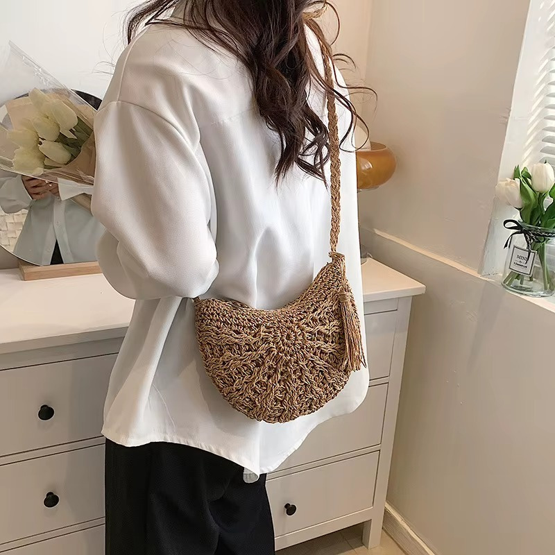 Sac en paille demi-cercle avec pompon et bandoulière porté sur l'épaule, modèle Amandine