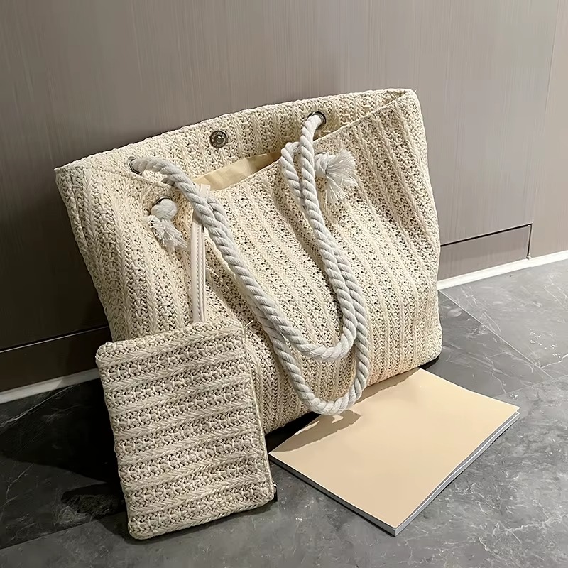 Sac En Paille Grand Format Fourre-Tout – Juliette Sac en paille grand format fourre-tout Juliette beige avec anses en corde et petite pochette assortie posés sur un sol gris