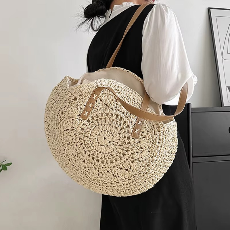 Sac En Paille Rond Ajouré Bandoulière – Solène Sac en paille rond ajouré avec bandoulière en cuir camel porté sur l'épaule