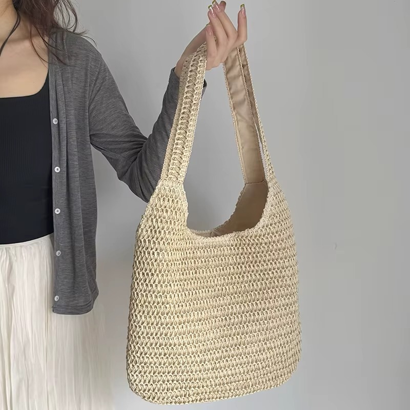 Sac En Paille Tissée Grande Capacité Double Anse – Camélia Sac en paille tissée grande capacité couleur camélia avec double anse porté par une personne