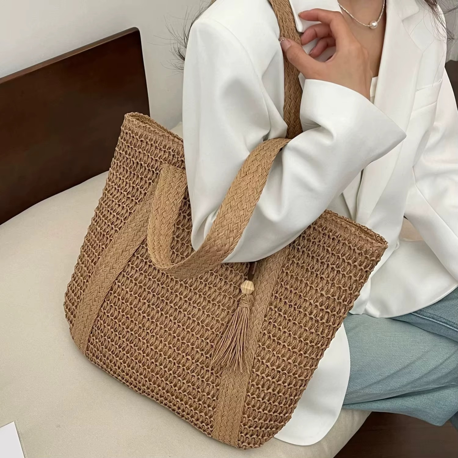 Sac En Paille Tressée Bandoulière – Paolita Sac en paille tressée naturel avec bandoulière large et pompon décoratif porté sur l'épaule