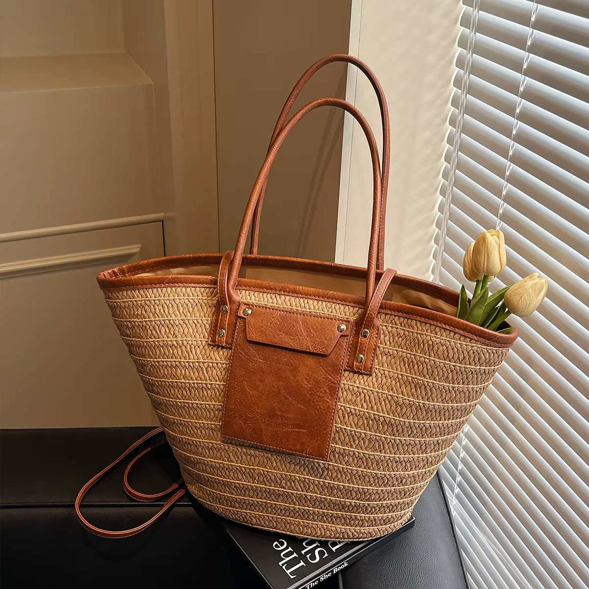 Sac en paille tressée cabas avec poche en cuir marron et rivets modèle Constance, vue de côté avec anses longues
