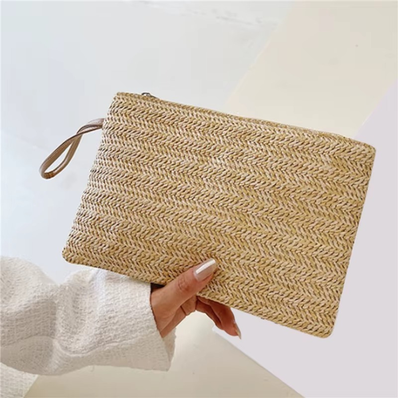 Sac En Paille Tressée Pochette Zippée Porte-Monnaie – Emma Sac en paille tressée pochette zippée porte-monnaie Emma beige tenue à la main avec poignée fine