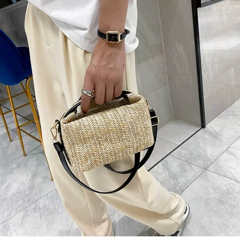 Sac en paille vintage rigide avec poignée et fermoir doré, bandoulière fine noire, porté à la main